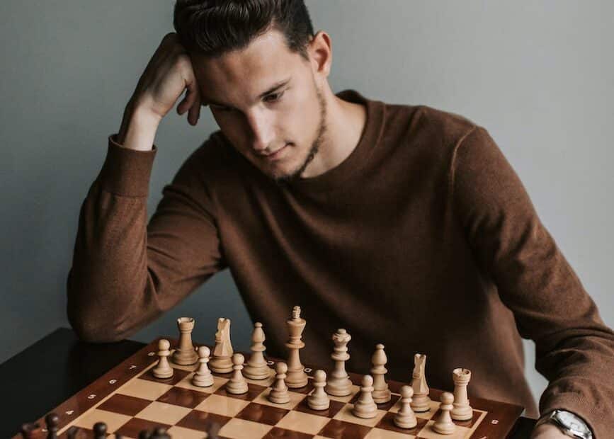 a man in brown sweater playing chess