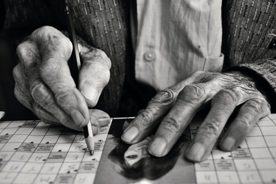 elderly man solving crossword