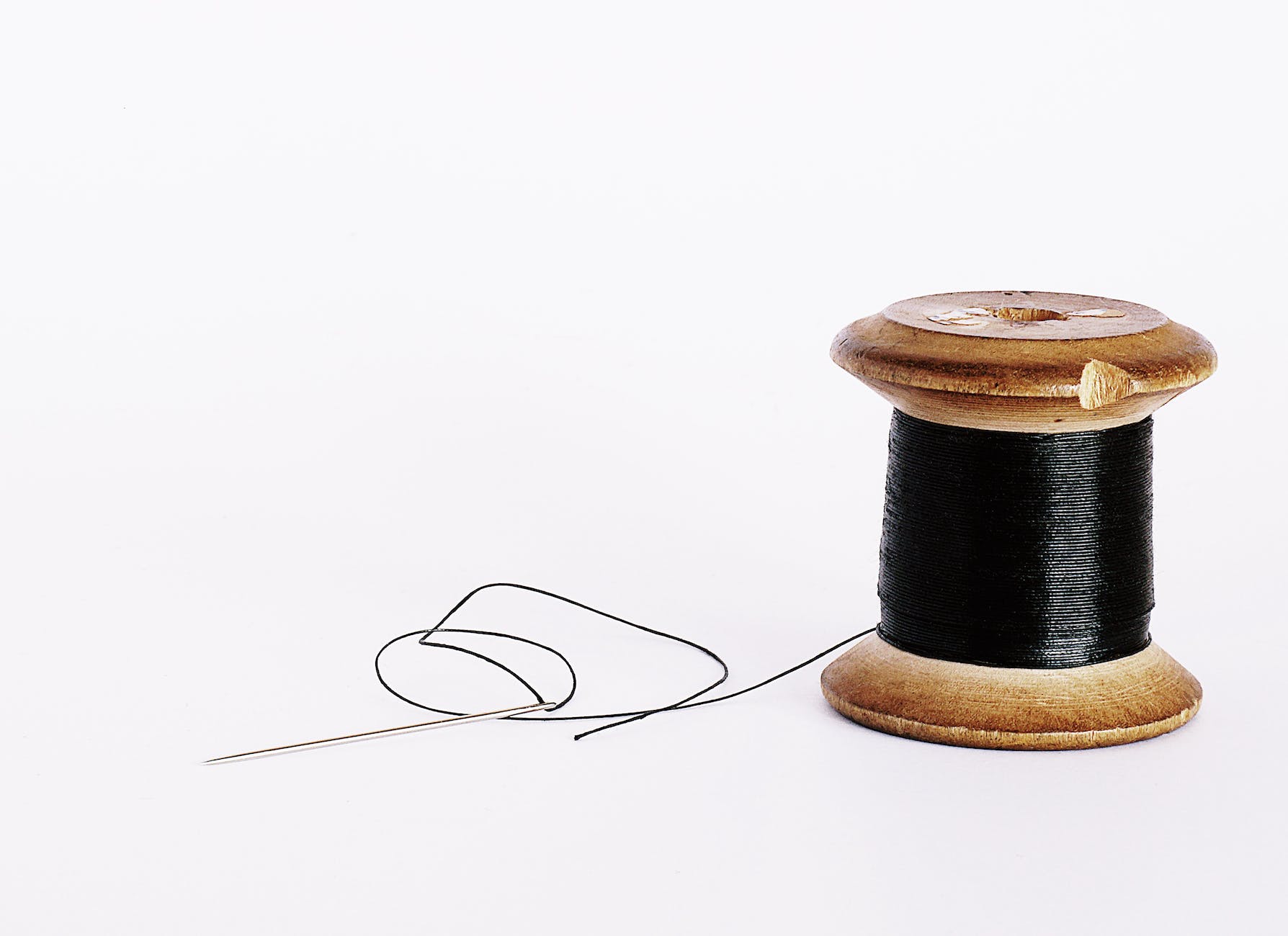 black thread on a wooden spool