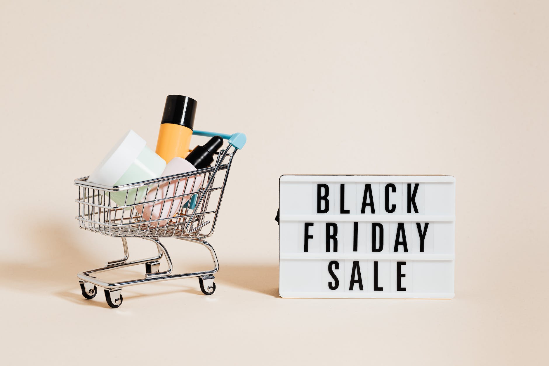 products in a shopping cart beside a black friday sale signage on beige background