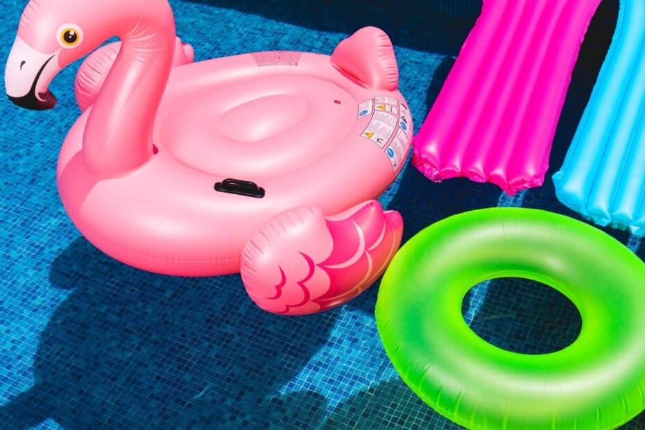 pink flamingo inflatable ring and green inflatable ring on swimming pool