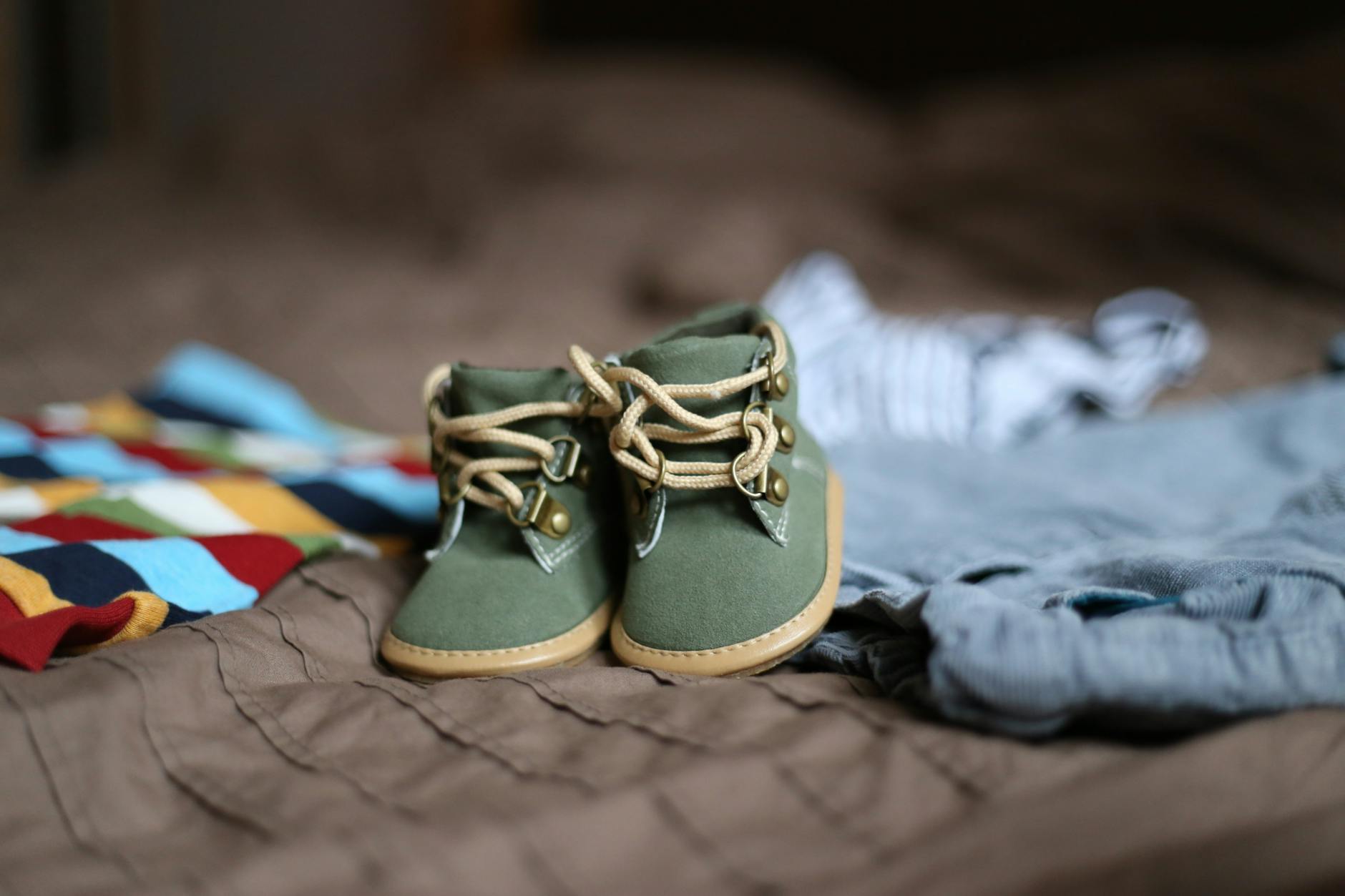 baby s green and beige sneakers on brown textile