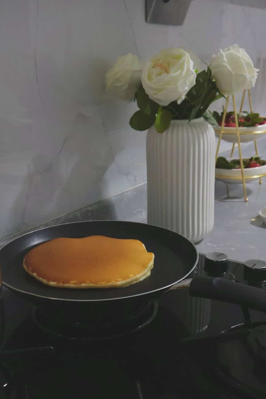 golden pancake with fresh roses in kitchen