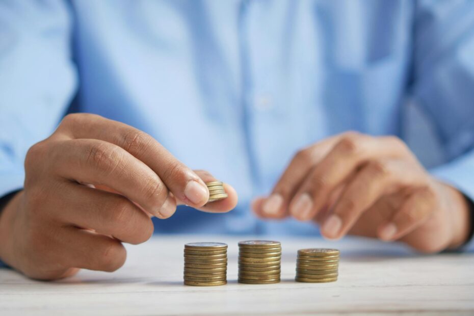 a close up shot of a person stacking coins