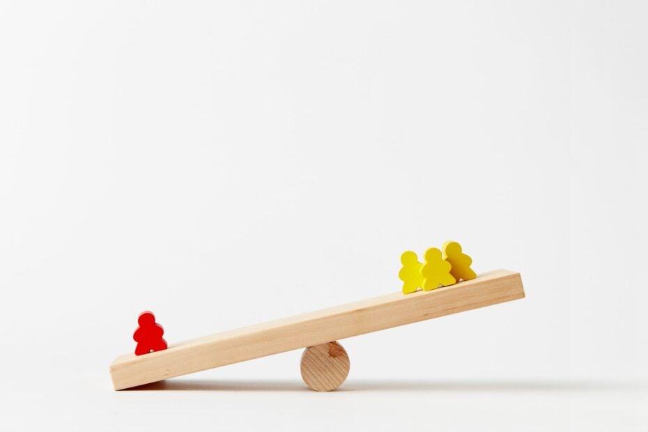 human shape blocks on wooden seesaw